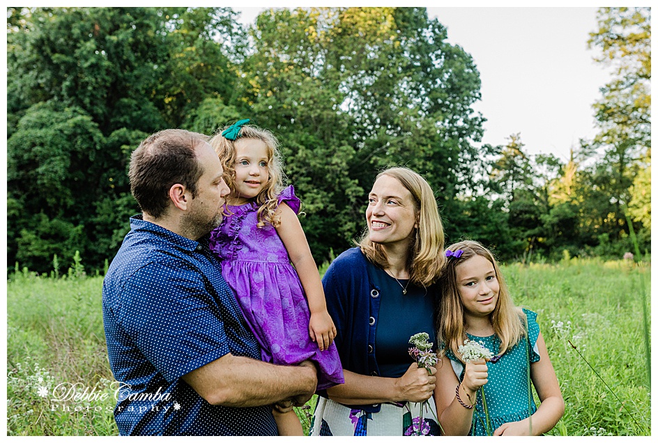 Family photo of parents and two girls to illustrate tips for a successful family photo session in Watchung Reservation
