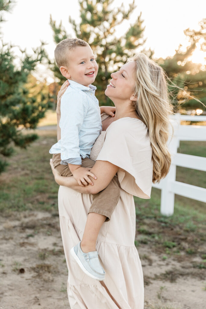 Beautiful woman holding adorable toddler in golden light in NJ