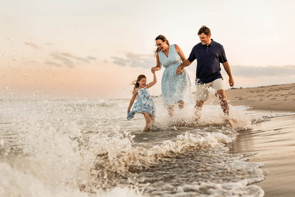 Joyful family splashing on the beach during a family photo session