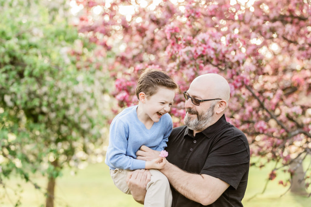 Father and son laughing during cherry blossom photoshoot in Scotch Plains, NJ
