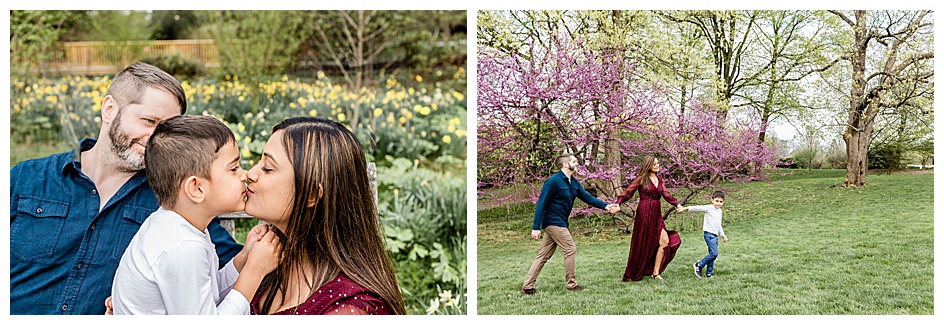 little boy kissing mom and family of three holding hands and walking next to a cherry blossom tree during family photoshoot at Frelinghuysen Arboretum