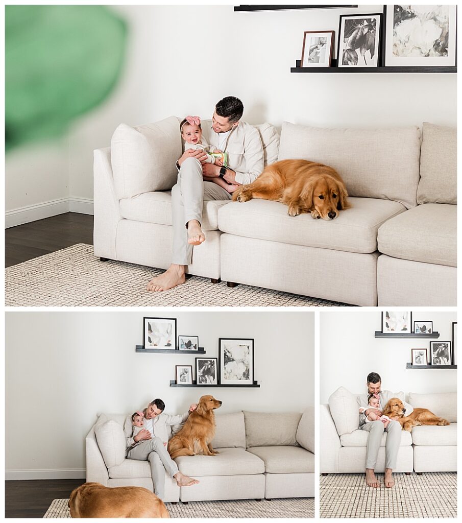 Dad holding baby on a white couch with a golden retriever