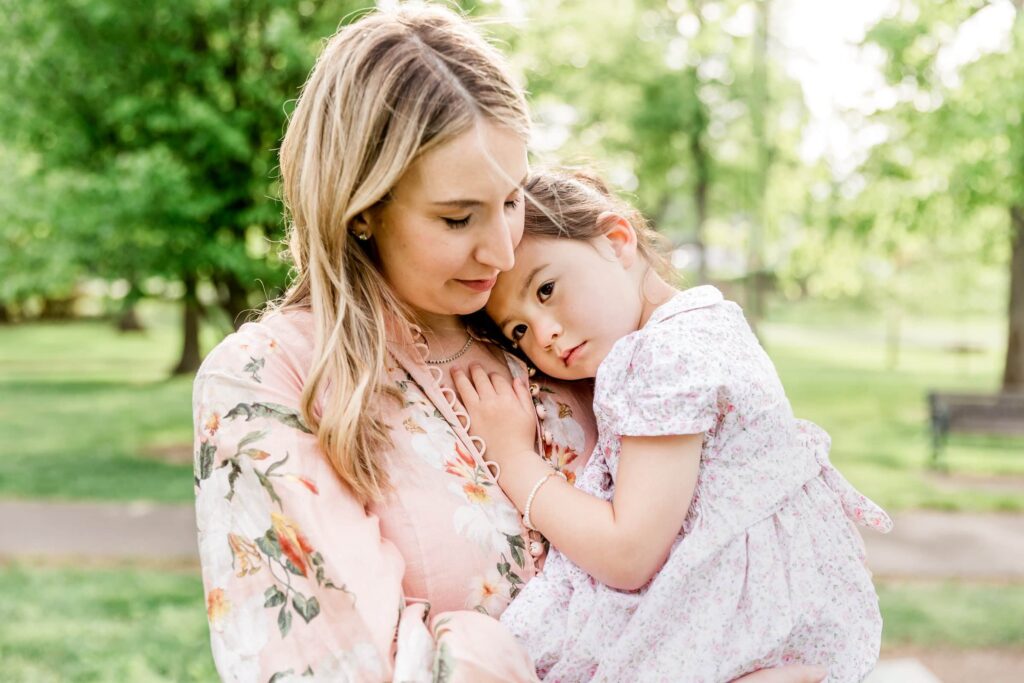 Little girl lays her head on mother illustrating an example perfect colors to wear for family photos in spring