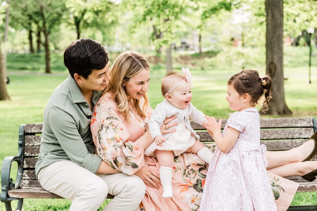 Family sitting on a bench in Mindowaskin Park during a spring photoshoot