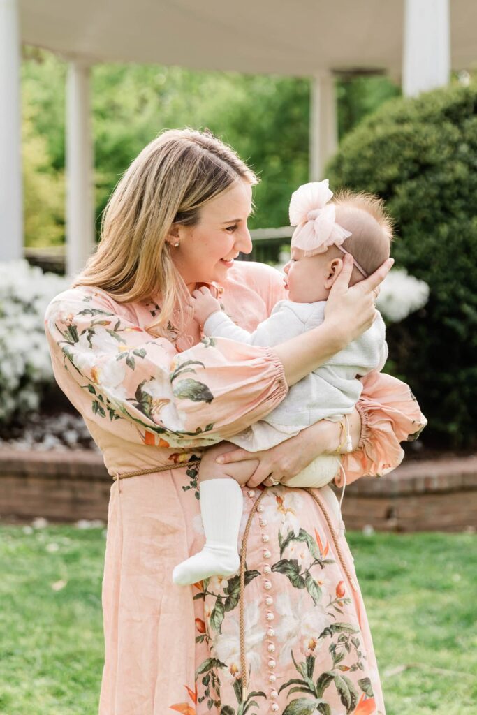 Mother loos lovingly at baby girl in an image showing perfect colors to wear for family photos in a spring session