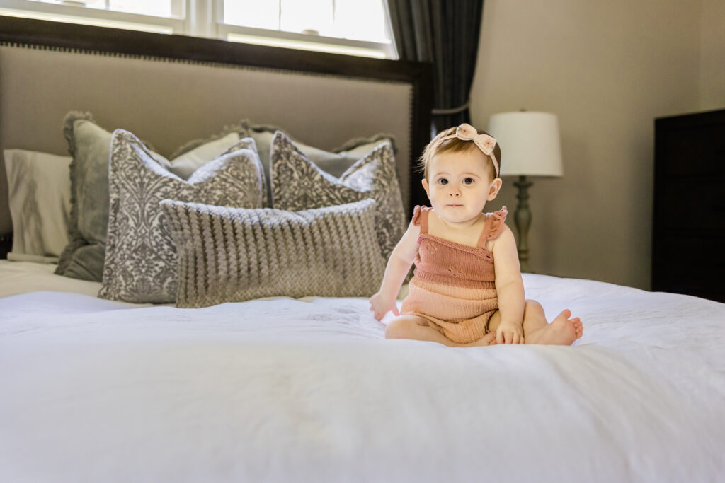 Baby girl sitting on bed