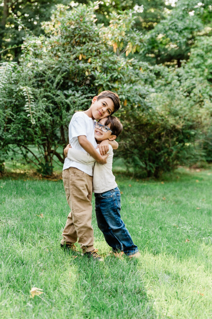 brothers hugging outside in their backyard