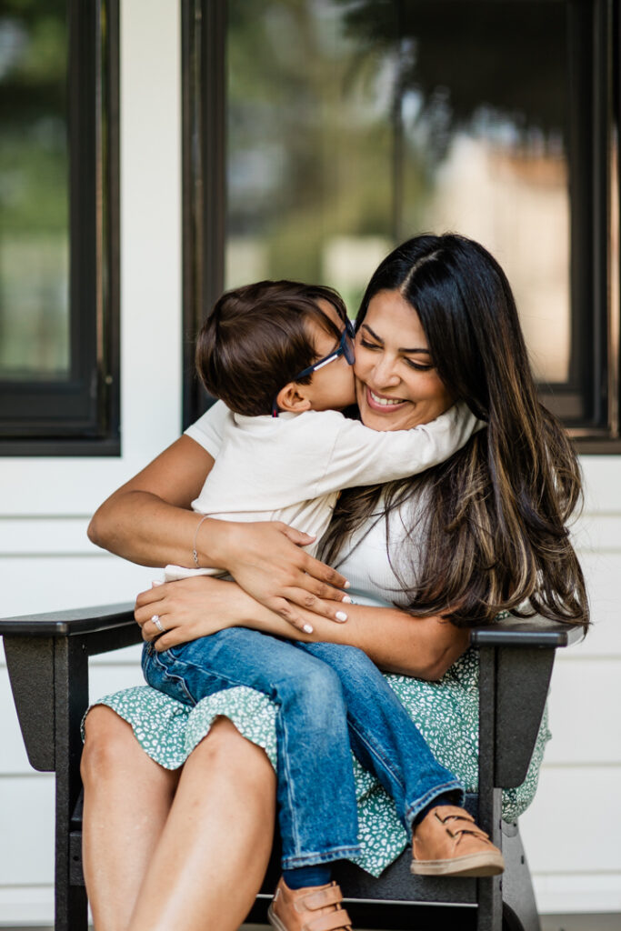 little boy embracing his mother lovingly while she smiles