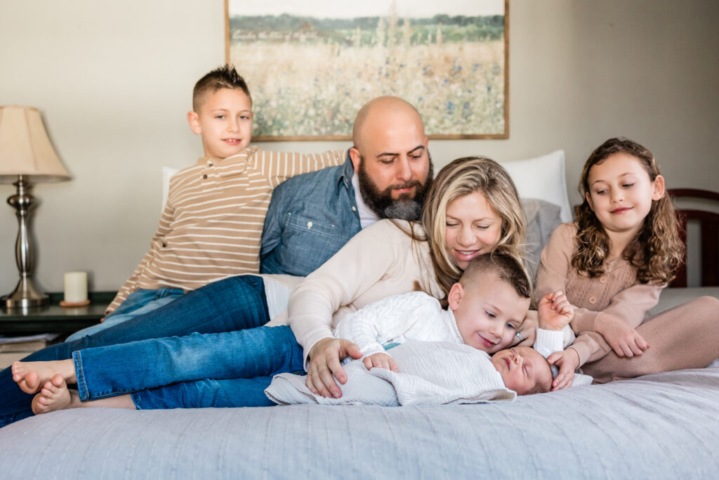 Family snuggled on be during in home newborn session