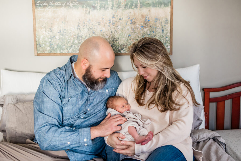 mother holding baby while father snuggles him close