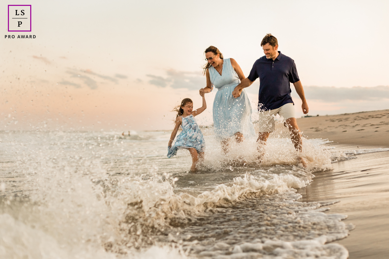 Joyful family walkingin the water at sunest in New Jersey
