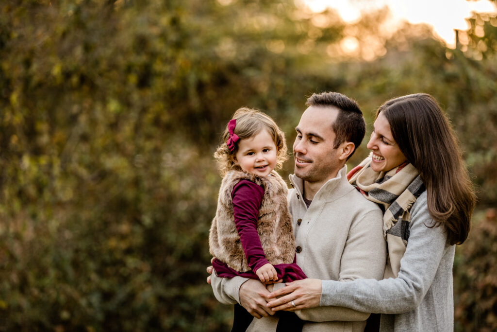 Many holding smiling toddler joyful golden light in Somerset County, NJ