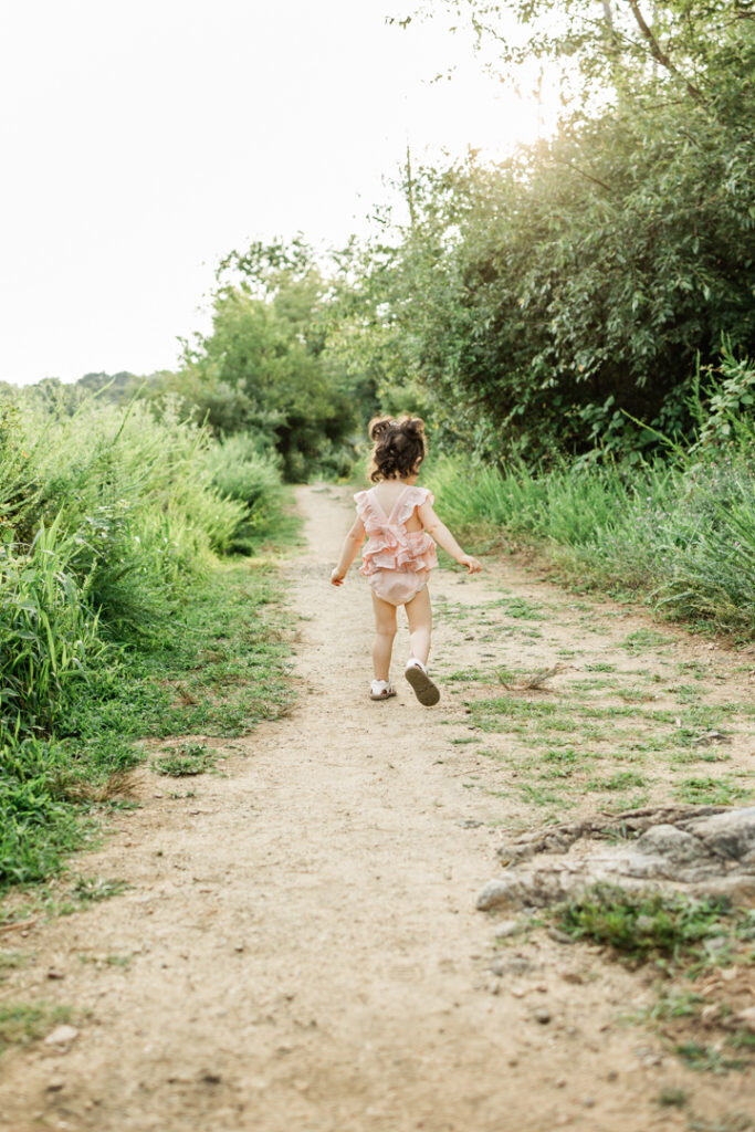 Toddler girl walking on sandy trail in Lebanon, NJ