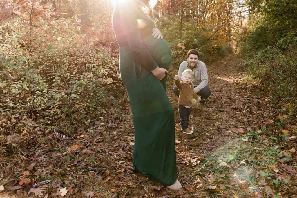 Thoughtful toddler boy exploring autumn foliage in Watchung Reservation during Union County maternity photos